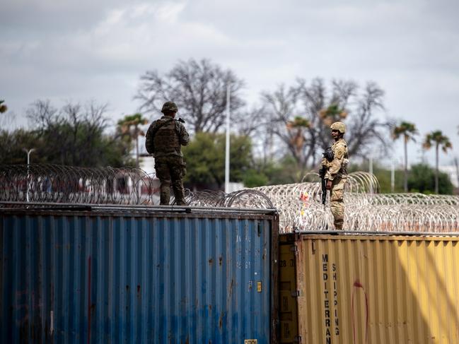 Texas National Guard troops patrol shipping containers overlooking the Rio Grande in Eagle Pass’s Shelby Park. Picture: Sergio Flores