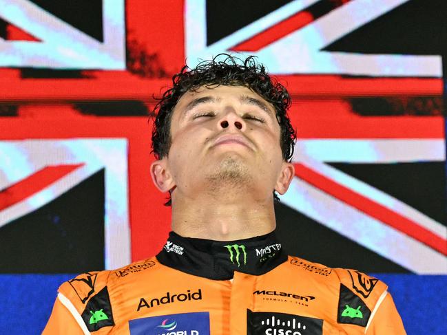 McLaren's British driver Lando Norris reacts on the podium as he celebrates winning the Formula One Singapore Grand Prix night race at the Marina Bay Street Circuit in Singapore on September 22, 2024. (Photo by MOHD RASFAN / AFP)