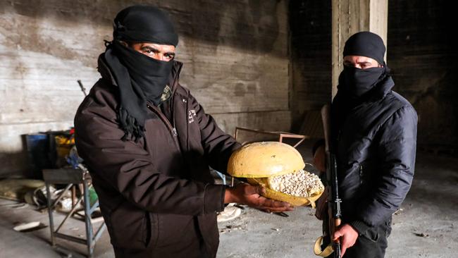 A Syrian rebel fighter holds a container of pills of Captagon, a brand name of the drug psychostimulant Fenethylline. Picture: AFP