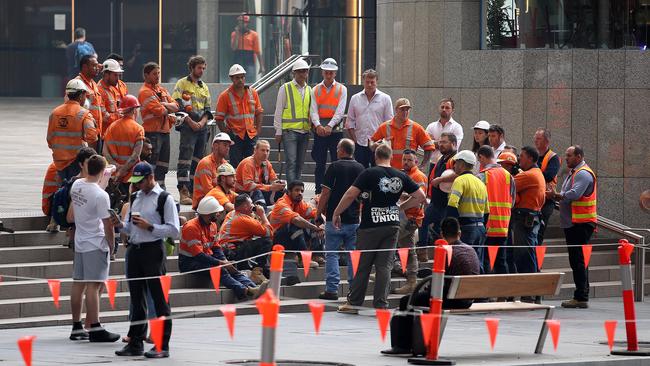 Workers from the building that caught on fire wait on the sidewalk. Picture: Sam Ruttyn.