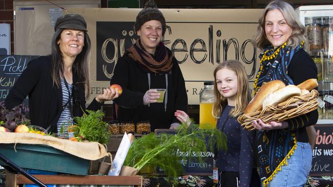 Willunga Farmers Market regulars Amanda Fleming from Willunga and Becky Hirst with Elsie Procter, 9, from Blewitt Springs, buying goods from Yasmin Whitehead at her stall Gut Feeling. Willunga Farmers Market has been named the best farmers market in Australia at the delicious. Harvey Norman Produce Awards. Picture: Emma Brasier.