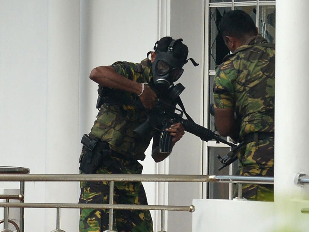 Sri Lankan Special Task Force personnel in gas masks are pictured outside a house during a raid. Picture: Ishara S Kodikara 