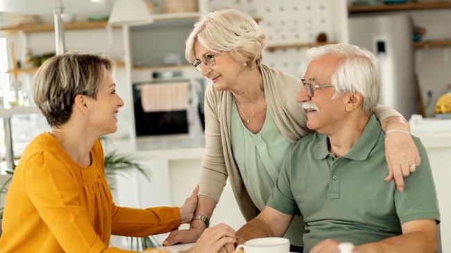 Happy woman visiting her senior parents and communicating with them at home. Family generic  Baby Boomers