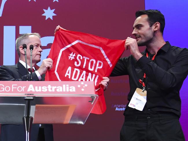 An 'Anti-Adani' protester gets on stage as Australian Opposition leader Bill Shorten speaks during day one of the Labor Party National Conference in Adelaide, Sunday, December 16, 2018. Labor's 48th National Conference will be held from Sunday 16 to Tuesday 18, December 2018 at the Adelaide Convention Centre. (AAP Image/Lukas Coch) NO ARCHIVING