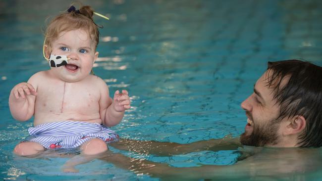 One of Ellie’s first days finally smiling in the rehab pool with dad Andrew after her surgery. Picture: Jason Edwards