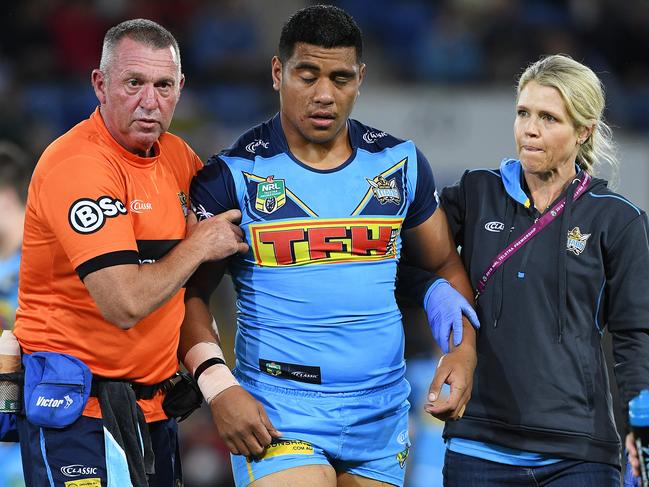 A dazed Moeaki Fotuaika is helped from the field. Picture: AAP