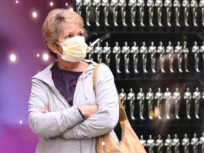 A woman wears a face mask while visiting the Walk of Fame in Hollywood, California March 10, 2020. - Hollywood is expecting a negative economic impact as a result of the global spread of the novel coronavirus, with major movie releases and entertainment events postponed and a precipitous drop in the number of tourists from China. (Photo by Robyn Beck / AFP)