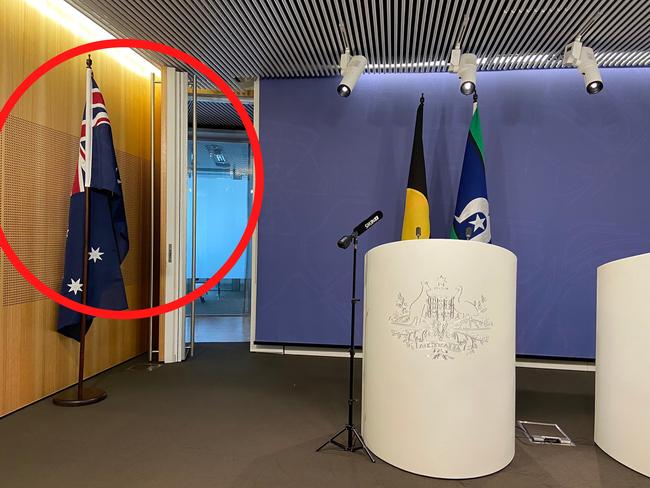 20/06/2022: An Australian flag is moved to the side of the room prior to Greens leader Adam Bandt conducting a press conference where he did not want to have the Australian flag and what it symbolises in the camera frame as he spoke.