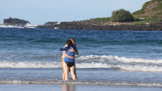 A couple hug one another at the scene of the tragedy at Fingal Head. Picture: Glenn Hampson