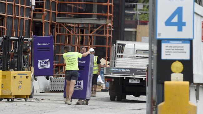 Workers remove equipment from a Propbuild construction site adjacent to Caulfield Racecourse in Melbourne's south-east. Picture: NCA NewsWire / Andrew Henshaw