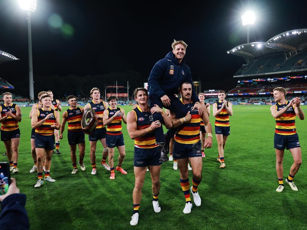 Sloane is chaired off by Matt Crouch and Walker. Picture: James Elsby/AFL Photos