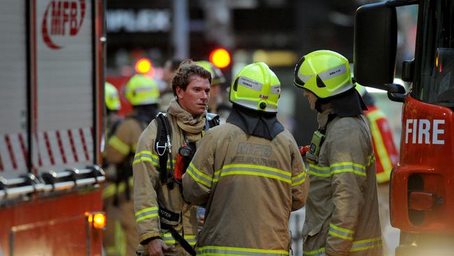 Firefighters talk among each other at the scene of the Spencer St blaze. Picture: Andrew Henshaw