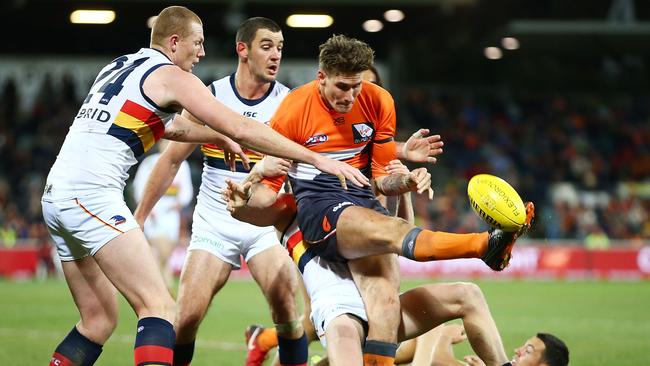 Rory Lobb of the Giants gets a kick away under pressure from Adelaide’s Sam Jacobs. Picture: Mark Nolan/Getty Images