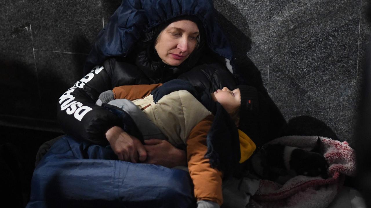 A mother watches her child sleep at Lviv train station in Western Ukraine. Picture: AFP