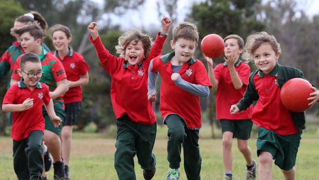 Rory Boys, Lawrence Coyte and Georgia Hale lead fellow Buxton Public School students celebrating the school’s $25,000 playground grant. Picture: Jonathan Ng