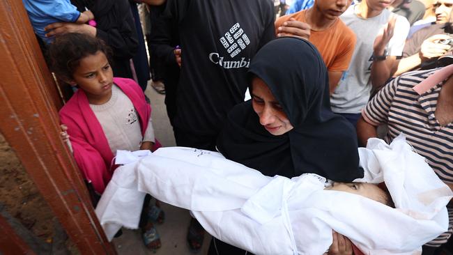 A woman holds the body of a baby ahead of a funeral procession of victims of an Israeli strike in Khan Yunis in the southern Gaza Strip, on May 14, 2025. Gaza's civil defence agency said at least 29 people were killed and dozens wounded in Israeli strikes on the war-battered Palestinian territory on May 14. (Photo by Eyad BABA / AFP)