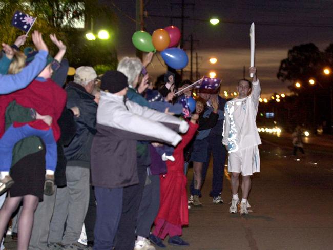 September 4, 2000: Runner Damien Pedersen gets prepared for his run through Kingswood during Penrith to Bowral leg of Sydney 2000 Olympic Torch Relay. Picture: Robert McKell.