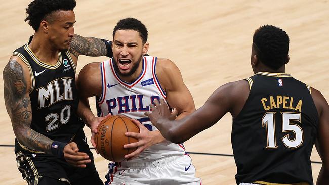ATLANTA, GEORGIA - JUNE 18:  Ben Simmons #25 of the Philadelphia 76ers drives between John Collins #20 and Clint Capela #15 of the Atlanta Hawks during the first half of game 6 of the Eastern Conference Semifinals at State Farm Arena on June 18, 2021 in Atlanta, Georgia.  NOTE TO USER: User expressly acknowledges and agrees that, by downloading and or using this photograph, User is consenting to the terms and conditions of the Getty Images License Agreement. (Photo by Kevin C. Cox/Getty Images)