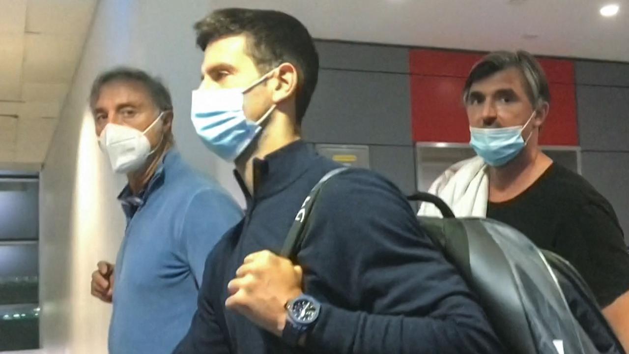 Serbia's Novak Djokovic (C) walking ahead of his coach Goran Ivanisevic (R) after they disembarked from their plane at the airport in Dubai after losing a legal battle on January 16 2022 in Australia to stay and play in the Australian Open. (Photo by AFPTV / AFP)