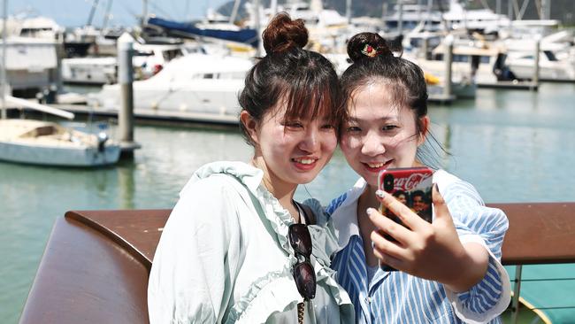 Chinese tourists Yingwen Jin and Yidie Xu take some holiday photos at the Cairns Marlin Marina, boosting tourism in Far North Queensland. PICTURE: BRENDAN RADKE