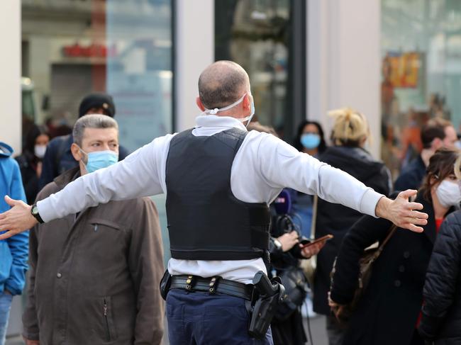 A French policeman pushes bystanders back off the street after a knife attack in Nice. Picture: AFP