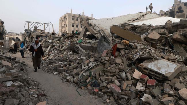 People walk near buildings levelled by Israeli bombardment in Rafah in the southern Gaza Strip on Sunday. Picture: AFP