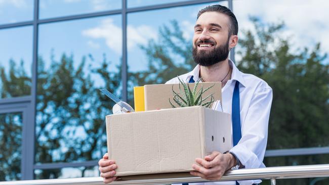 happy businessman with cardboard box with office supplies in hands standing outside office building, quitting job concept. quit job happy. ISTOCK