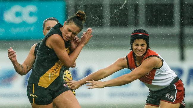 the NTFL's Claudia Fabris, right and Glenelg’s Taylah Scapens grimace in the wet conditions at TIO Stadium. Picture GLENN CAMPBELL