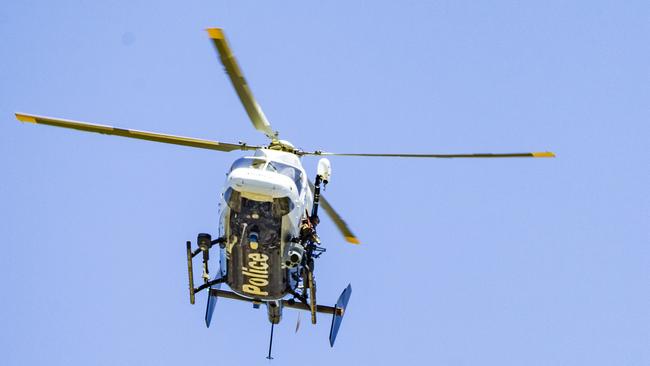 A police marksman watched from a helicopter over the proceedings. Picture: Tony McDonough