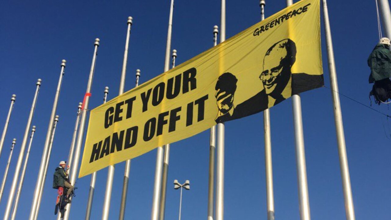 Greenpeace protestors scale flagpole outside federal parliament