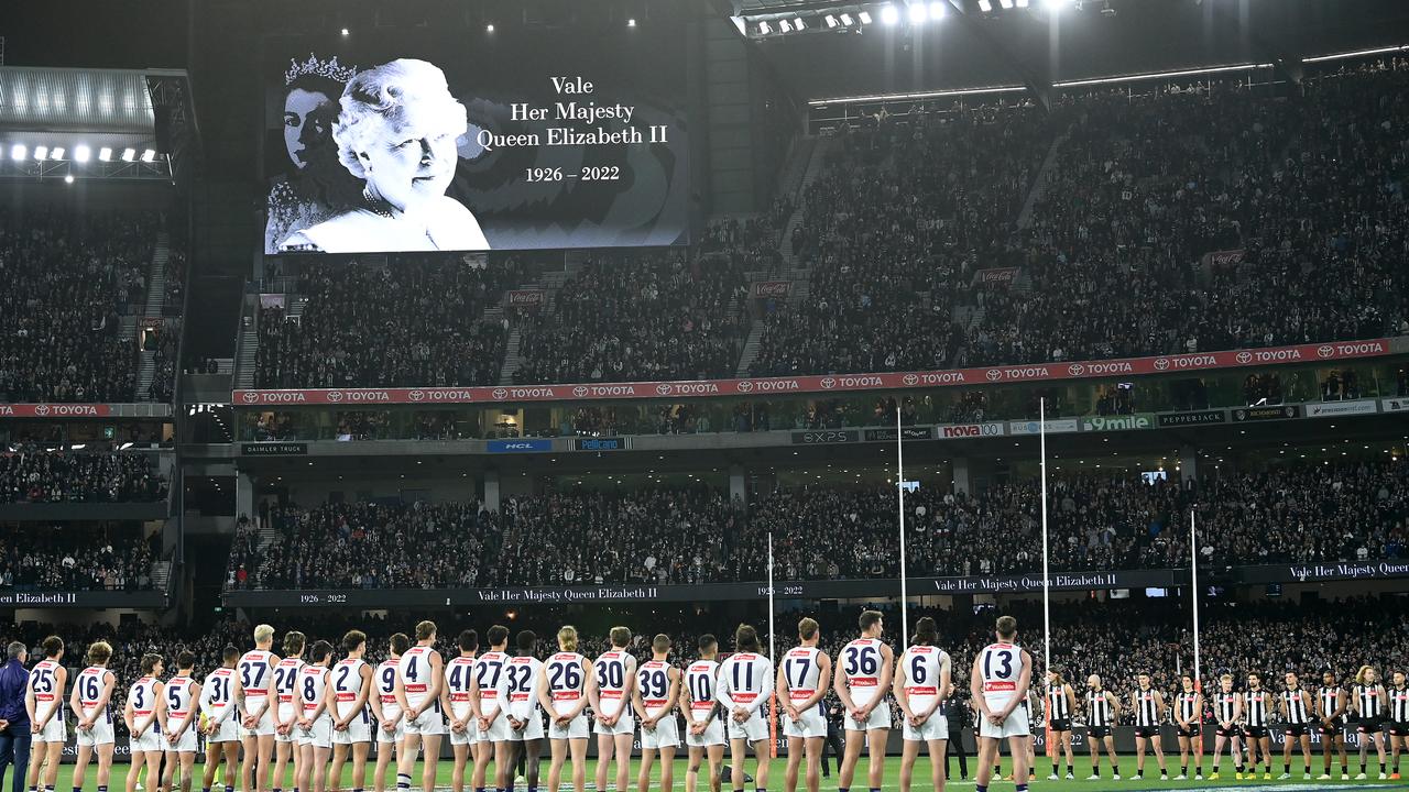 Players stand for a minute silence in memory of Her Majesty Queen Elizabeth II during the AFL First Semifinal match between the Collingwood Magpies and the Fremantle Dockers on Saturday night. AFLW chose not to follow suit. (Photo by Quinn Rooney/Getty Images)