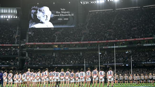 Players stand for a minute silence in memory of Her Majesty Queen Elizabeth II during the AFL First Semifinal match between the Collingwood Magpies and the Fremantle Dockers on Saturday night. AFLW chose not to follow suit. (Photo by Quinn Rooney/Getty Images)