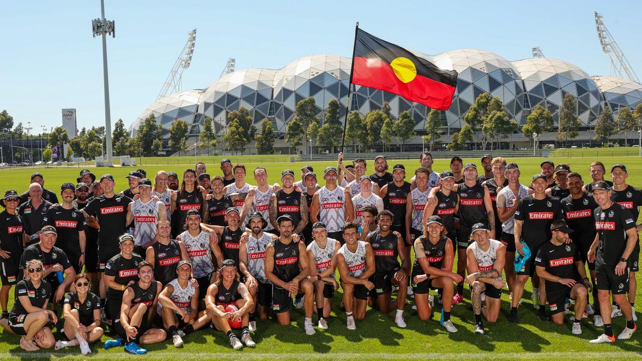 Collingwood players pose with the Aboriginal flag on January 26.