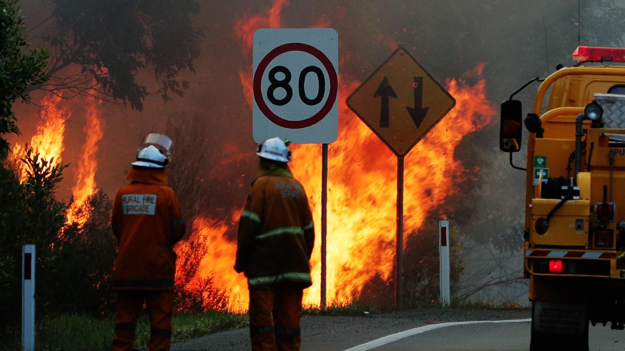 Rural firefighters work to control a blaze near the Sunshine Coast motorway. Picture: Lachie Millard