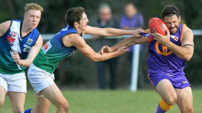 Three-time Brisbane Lions premiership player Chris Johnson fends off an East Sunbury opponent in the Jacana’s Queen’s Birthday Monday clash. Photo: Kris Reichl