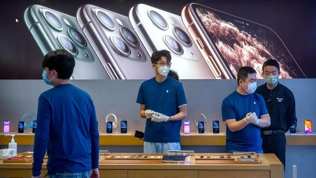 Employees wear face masks as they stand in a reopened Apple Store in Beijing. Picture: AP