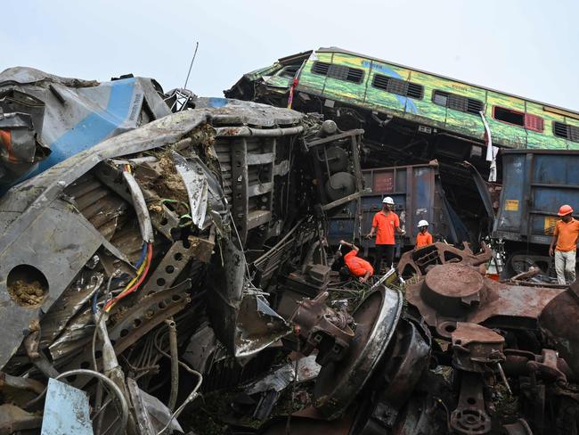 Rescue workers sift through wreckage at the accident site of a three-train collision near Balasore, about 200 km (125 miles) from the state capital Bhubaneswar in the eastern state of Odisha, on June 3, 2023. At least 288 people were killed and more than 850 injured in a horrific three-train collision in India, officials said on June 3, the country's deadliest rail accident in more than 20 years. (Photo by Dibyangshu SARKAR / AFP)