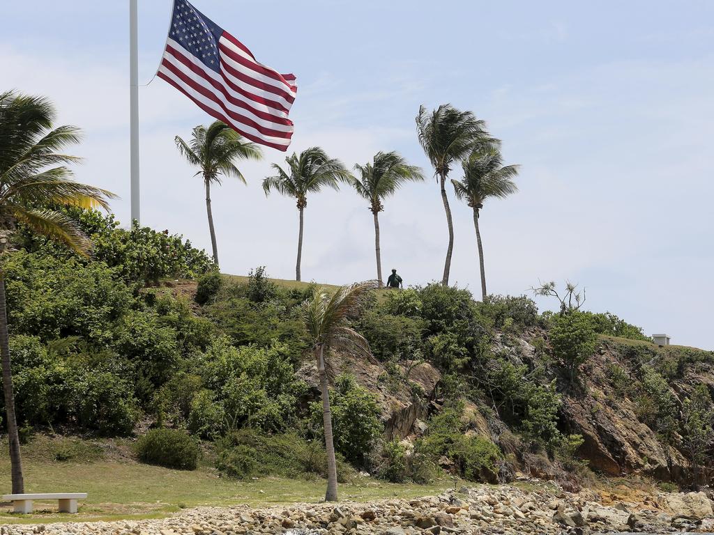 A man stands near a US flag at half staff on Little St. James Island, in the US Virgin Islands, a property owned by Jeffrey Epstein. Picture: Gabriel Lopez Albarran