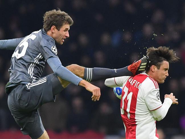 Bayern Munich's German forward Thomas Mueller (L) kicks the back of Ajax's Aregntine defender Nicolas Tagliafico during the UEFA Champions League Group E football match between AFC Ajax and FC Bayern Munchen at the Johan Cruyff Arena in Amsterdam on December 12, 2018. (Photo by EMMANUEL DUNAND / AFP)