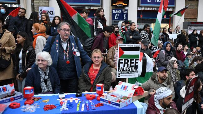 Fundraisers for the Royal British Legion selling poppies surrounded by protesters inside Charing Cross station on London. Picture: AFP