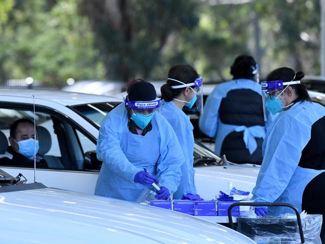 Health workers dressed in personal protection equipment collect patient information prior to Covid-19 testing in Sydney. Picture: NCA NewsWire/Bianca De Marchi