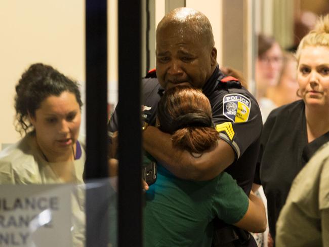 A Dallas Area Rapid Transit police officer receives comfort at the Baylor University Hospital emergency room entrance Thursday, July 7, 2016, in Dallas. Picture: Ting Shen