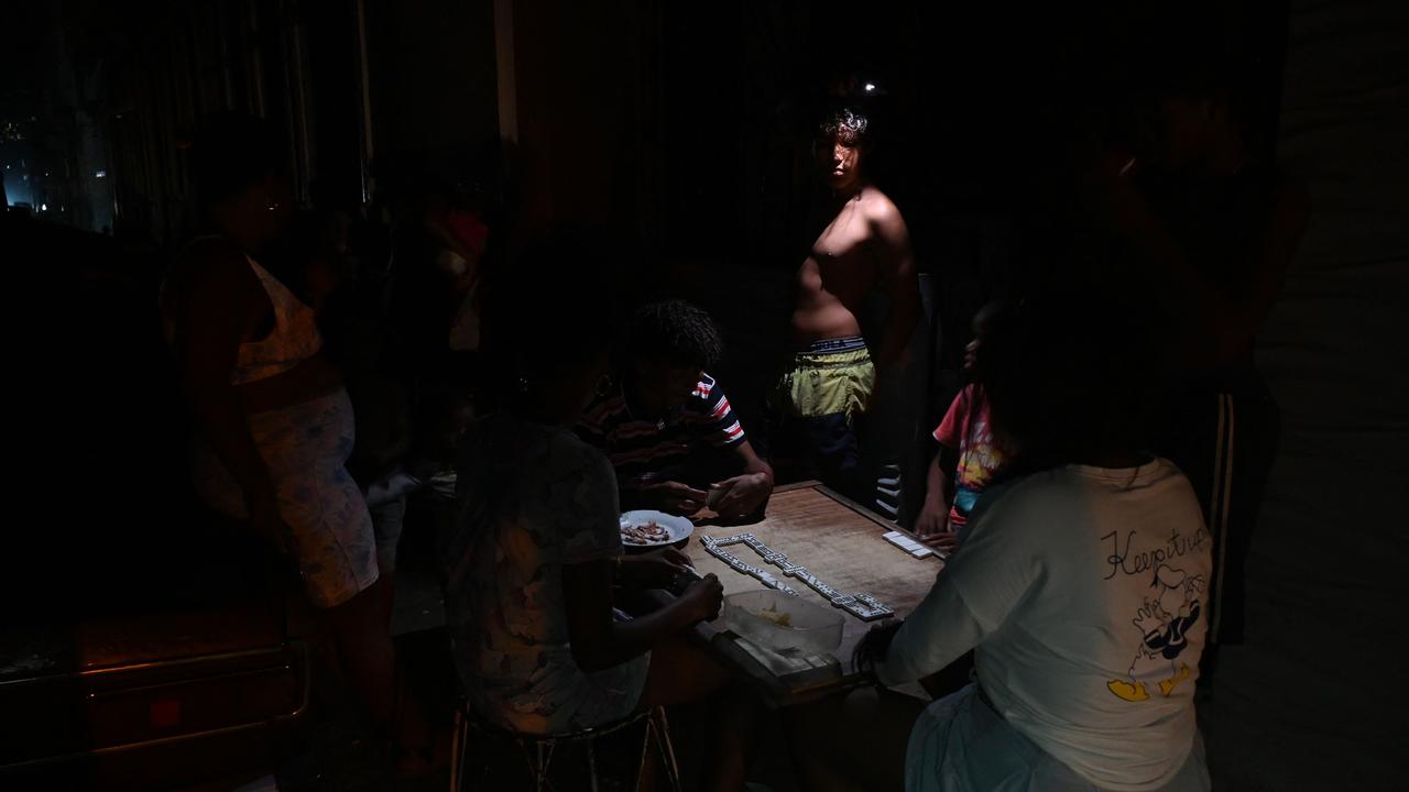 Cubans play dominoes in the dark on a street. Picture: Yamil Lage/AFP