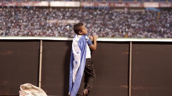 A young Honduras fan wears a Honduras national flag as a cape