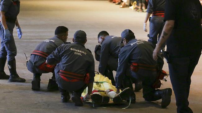 Tales Soares is taken from the catwalk by paramedics after he collapsed. Picture: AP 