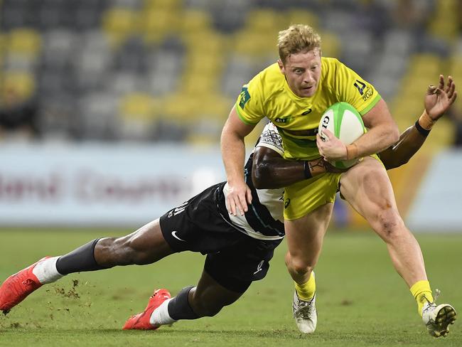 Lachlan Miller of Australia is tackled during the Oceania Sevens Challenge match between Fiji and Australia at Queensland Country Bank Stadium. (Photo by Ian Hitchcock/Getty Images)