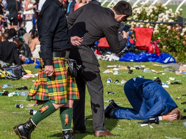 A racegoer shelters unsuccessfully from a photograph. Picture: Jake Nowakowski