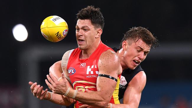 Patrick Cripps of the Blues tackles Jesse Lonergan of the Suns during the Round 19 AFL match at Metricon Stadium. Picture: AAP Image/Dave Hunt