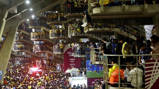 Spectators take shelter from rain under the stadium.