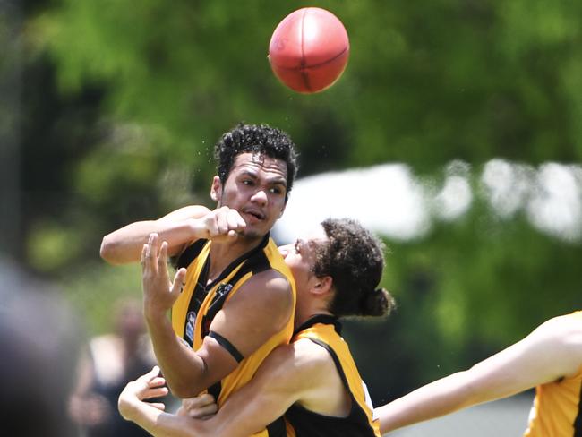 Hawks player Robert Campbell passes off before Nightcliff player Caleb Walker could intercept